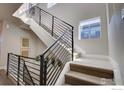 Modern staircase with metal railings and large windows provides natural light and a contemporary feel at 7861 W 51St Ave, Arvada, CO 80002