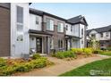 Street view of modern townhomes with a combination of brick and corrugated metal exteriors, complemented by lush landscaping at 9305 S Gore St # C, Arvada, CO 80007