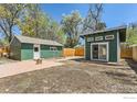 Backyard featuring a modern studio, shed, brick patio, and fenced yard at 1136 Venice St, Longmont, CO 80501