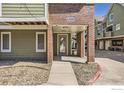 Close up of an Ashley Court unit entrance showing the walkway and porch at 1300 S Monaco Pkwy # 12, Denver, CO 80224