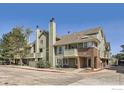 View of Ashley Court units with green siding, brick accents and chimneys at 1300 S Monaco Pkwy # 12, Denver, CO 80224