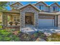 Inviting stone archway leads to a charming entrance with a beautifully landscaped front yard at 14180 Whitney Cir, Broomfield, CO 80023