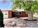 Quaint brick home featuring mature trees and a two-car garage at 1701 Jewel Dr, Longmont, CO 80501