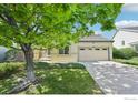 Charming exterior featuring a manicured lawn and mature tree, creating an inviting curb appeal at 2420 E 127Th Ave, Thornton, CO 80241