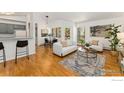 Bright living room featuring hardwood floors, white couches, modern decor, and an adjacent dining area at 3515 28Th St # 201, Boulder, CO 80301