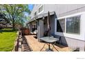 Wooden deck with outdoor seating, including a table, chairs, and a swing with green yard views at 4150 Monroe Dr # C, Boulder, CO 80303