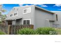Exterior view of a well-maintained grey home with a fenced yard and green shrubs at 4150 Monroe Dr # C, Boulder, CO 80303