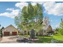 Charming home with mature trees, a well-manicured lawn, and a detached two-car garage at 474 W Spruce St, Louisville, CO 80027