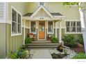 Inviting front porch with a wooden rocking chair, potted plants, and a charming entrance at 474 W Spruce St, Louisville, CO 80027