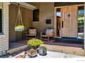 Inviting front porch with seating, stylish decor, and a modern wooden door, creating a welcoming entrance at 505 Lois Dr, Louisville, CO 80027