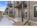 Townhome featuring brick accents, covered entry, and low-maintenance landscaping at 5173 Vivian St, Wheat Ridge, CO 80033