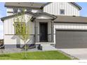 Elegant front entrance featuring a dark-colored door, contrasting trim, and manicured lawn at 5900 Sunrise Pl, Longmont, CO 80504