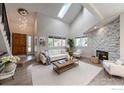 Bright and airy living room with vaulted ceilings, a stone fireplace, and large windows that fill the space with light at 5978 Scotswood Ct, Boulder, CO 80301