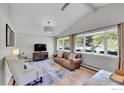 Bright living room featuring vaulted ceilings, large windows, and hardwood floors at 714 S Longmont Ave, Lafayette, CO 80026