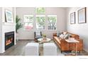 Bright living room with large windows, modern furniture, and a cozy fireplace at 725 Arrowood St, Longmont, CO 80503