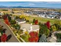 Aerial view of a luxury home nestled amongst trees with views of distant mountains at 725 E Wiggins St, Superior, CO 80027