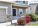 Charming home featuring a covered porch, stone accents, and vibrant red roses, creating a welcoming entrance at 920 Wagon Bend Rd, Berthoud, CO 80513