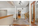 Inviting foyer with carpeted floors, wooden banister, and view into the kitchen at 10547 Lipan St, Northglenn, CO 80234