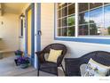Cozy front porch featuring comfortable wicker seating and cheerful yellow accents, perfect for relaxing outdoors at 1264 Banner Cir, Erie, CO 80516