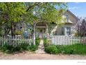 Quaint home featuring a welcoming picket fence and an arched entryway adorned with blooming vines at 1341 N 95Th St, Lafayette, CO 80026