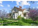 Charming Victorian home with a well-manicured lawn, decorative porch, and vibrant spring blossoms at 1341 N 95Th St, Lafayette, CO 80026