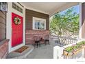 Covered front porch with a red door, decorative wreath, and seating area, perfect for relaxing at 13668 Plaster Cir, Broomfield, CO 80023