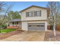 Charming two-story home with a manicured lawn, mature tree, and attached garage at 1506 Fisk Ct, Longmont, CO 80503