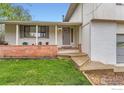 Inviting front porch with brick accents, seating, and decorative plants at 1506 Fisk Ct, Longmont, CO 80503
