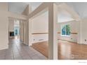 Open-concept living space with wood floors, decorative columns, and plenty of natural light at 1606 Iris St, Broomfield, CO 80020
