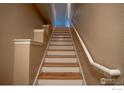 A well-lit staircase with wooden steps and white trim accents at 2092 N Concord Ln, Superior, CO 80027