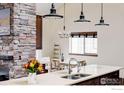 Kitchen island with double sink, modern faucet, and decorative flowers in a white vase at 2770 Arbor Glen Pl, Boulder, CO 80304