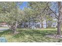 Exterior view of condo building surrounded by lush trees, a sprawling lawn, and manicured landscaping at 3363 Oneal Pkwy # 36, Boulder, CO 80301