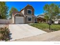 View of home with a wide driveway, lawn and landscaping at 5298 S Zeno Way, Centennial, CO 80015