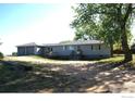 View of the back exterior featuring a deck, siding, windows and access to a detached two-car garage at 6363 County Road 20, Longmont, CO 80504
