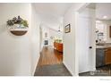 Open hallway leading to a living room with a fireplace and hardwood flooring at 6721 E 114Th Ave, Thornton, CO 80233