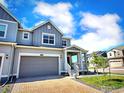 Inviting townhome showcasing a well-kept lawn, a spacious two-car garage, and a charming front porch at 700 Lillibrook Pl, Erie, CO 80026