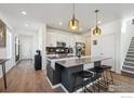 Modern kitchen featuring a large island, stainless steel appliances, and stylish pendant lighting at 700 Lillibrook Pl, Erie, CO 80026