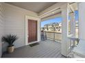 Inviting covered front porch with gray flooring and white pillars, creating a cozy outdoor space at 700 Lillibrook Pl, Erie, CO 80026