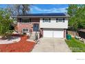 Charming split-level home featuring solar panels, a manicured yard, and a two-car garage at 8351 Ralph Ln, Denver, CO 80221