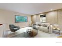 Cozy living room with neutral tones, textured wallpaper, and large window at 8351 Ralph Ln, Denver, CO 80221