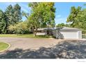 Nice home with a circular driveway and a large detached garage on a tree-filled lot at 8813 Baseline Rd, Lafayette, CO 80026