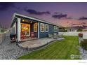 Inviting backyard with a covered patio and manicured lawn, perfect for outdoor enjoyment at 8938 Ferncrest St, Longmont, CO 80504