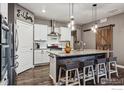 Modern kitchen with island seating, white cabinets, and stainless steel appliances at 8938 Ferncrest St, Longmont, CO 80504