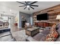 Stylish living room featuring a wood accent wall and modern furnishings at 8938 Ferncrest St, Longmont, CO 80504