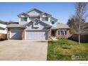 Beautiful two-story home with a three car garage, manicured lawn, and attractive brick accents at 1009 Monarch Way, Superior, CO 80027