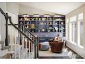 Bright living space showcases a custom built-in bookshelf and elegant staircase at 1009 Monarch Way, Superior, CO 80027