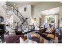Spacious living room featuring comfortable seating, elegant stairs and a view into the dining area at 1009 Monarch Way, Superior, CO 80027