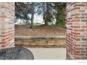 View of landscaped yard from an outdoor patio with rustic stone retaining wall at 1089 Laramie Blvd, Boulder, CO 80304