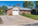 Charming brick home featuring a well-maintained lawn and attached garage at 111 Barbara St, Louisville, CO 80027