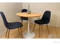 Modern dining area with a pedestal table, three stylish chairs, and a decorative vase at 1111 Maxwell Ave # 109, Boulder, CO 80304